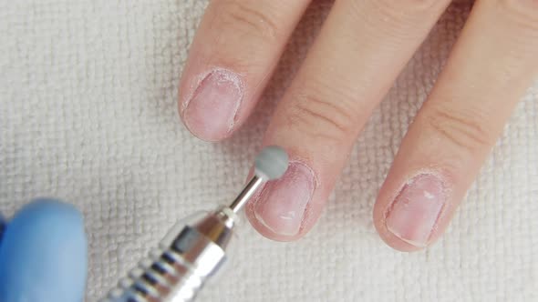 Young Woman Removes Gel Shellac Polish From Nails Using Manicure Machine