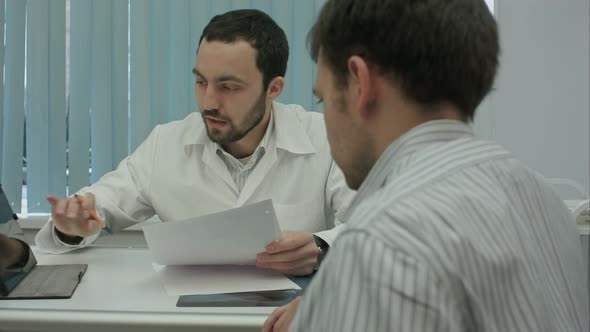 Male Bearded Doctor with Tablet Consult Client