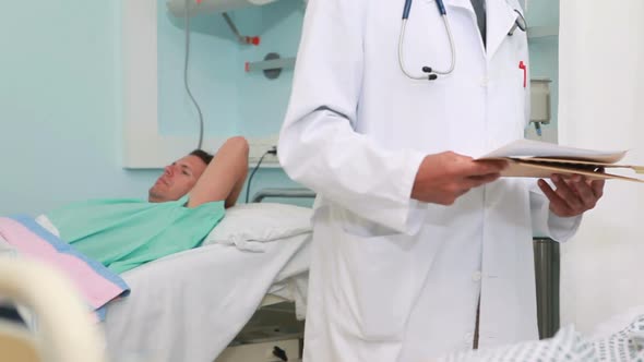 Doctor talking with a patient in a bed ward