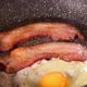 Frying pork bacon strips and one egg - VideoHive Item for Sale