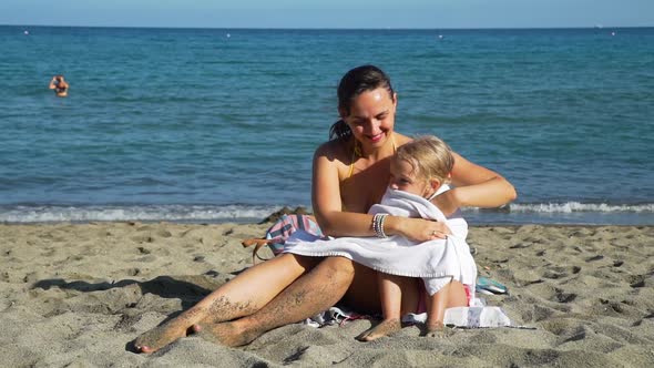 Mother Covering Daughter with a Towel on a Beach