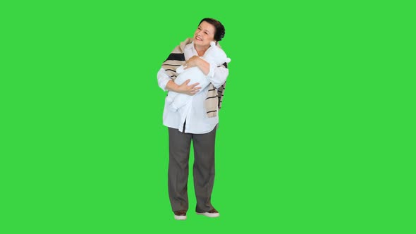 Happy Grandmother Cuddling Her Granddaughter or Grandson on a Green Screen Chroma Key