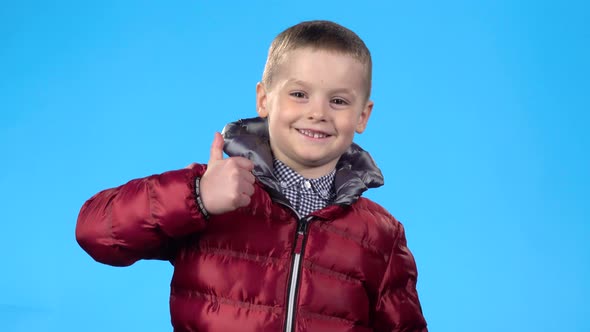 Kid Showing Thumbs Up, Laughing and Looking at the Camera
