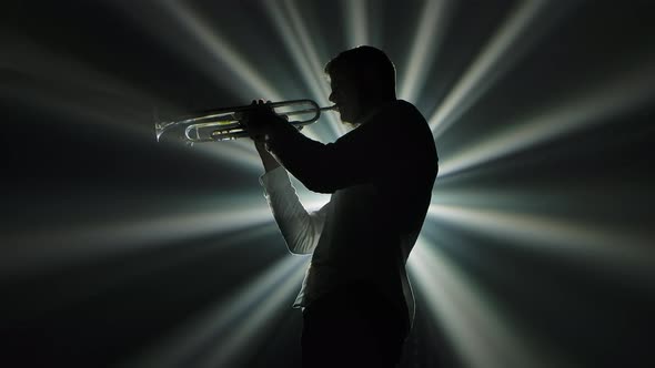 Solo Performance of the Melody on the Trumpet. A Black Silhouette of a Man Against a Background of