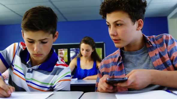 Student using mobile phone in classroom