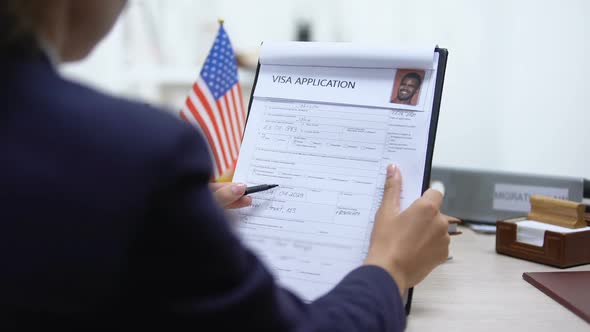 Immigration Officer Approving Visa Application, American Flag on Table, Tourism