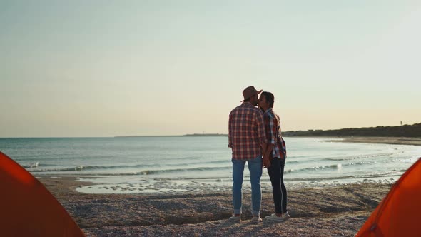 Beautiful Asian Woman Lovely Looking and Kissing Man in Hat on Sea Beach at Sunset