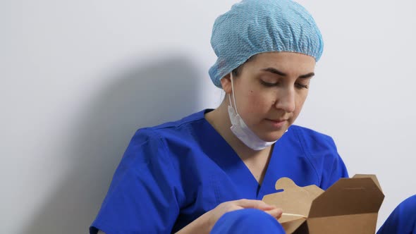 Sad Doctor or Nurse Eating Takeaway Food From Box