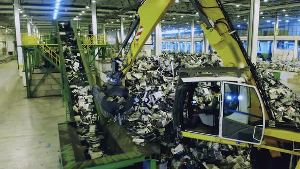 Working Tractor Loads a Container with Trash