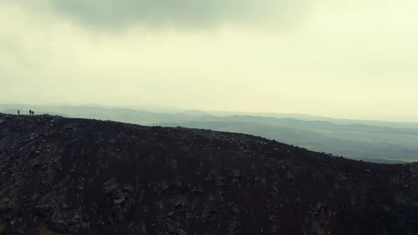 People On Steep Mountains Overlooking Misty Ridges. - Aerial Drone Shot