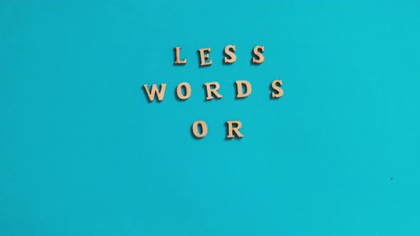Time Lapse of Quote LESS WORDS MORE ACTION Made Out of Wooden Letters on Bright Blue Background