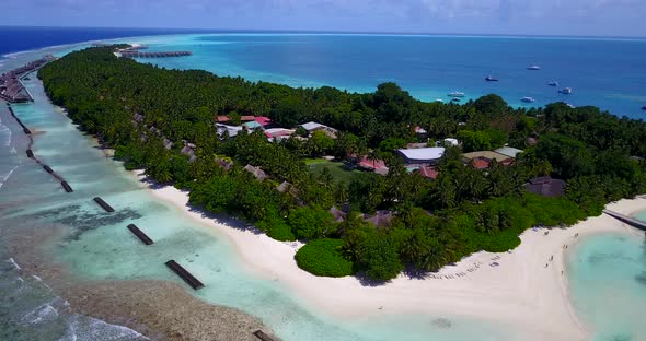 Daytime overhead copy space shot of a white sandy paradise beach and aqua blue ocean background 