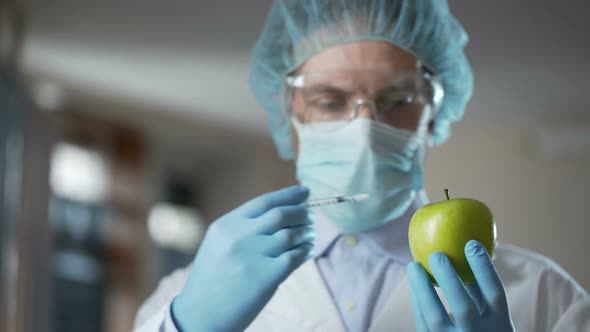 Laboratory Worker Injecting Apples With Chemicals, Adding Smell and Juiciness