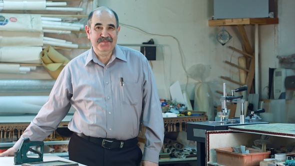 Portrait of a senior male business owner behind the counter