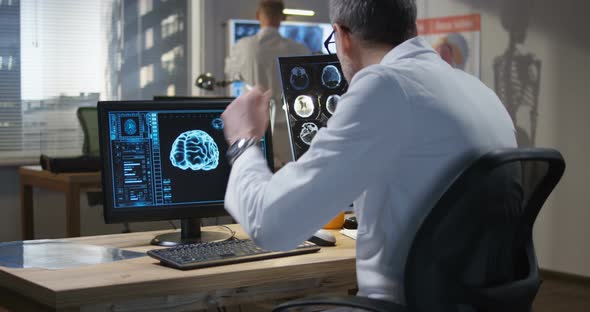 Doctor Analyzing X Ray and Brain Scan