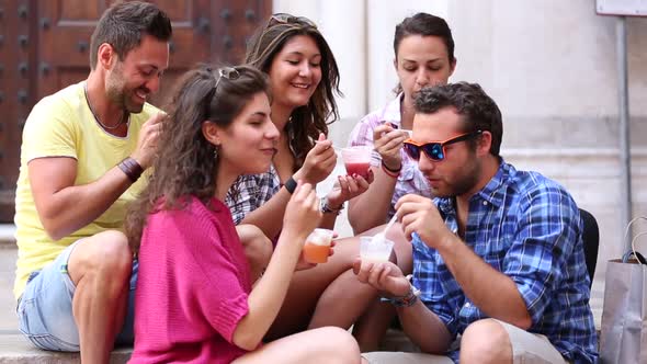 Tourists or friends eating ice cream slush and having fun