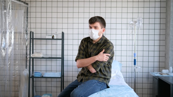 Young man wearing protective mask sitting alone in the