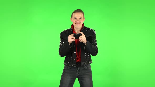 Guy Playing a Video Game Using a Wireless Controller and Rejoicing in Victory. Green Screen