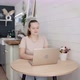 Woman is Working on Laptop Sitting at the Kitchen Table at Home - VideoHive Item for Sale