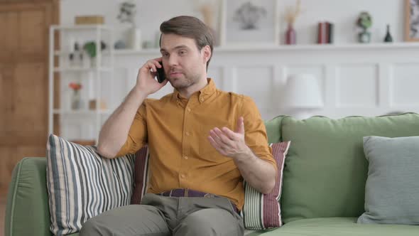 Young Man Talking on Phone on Sofa