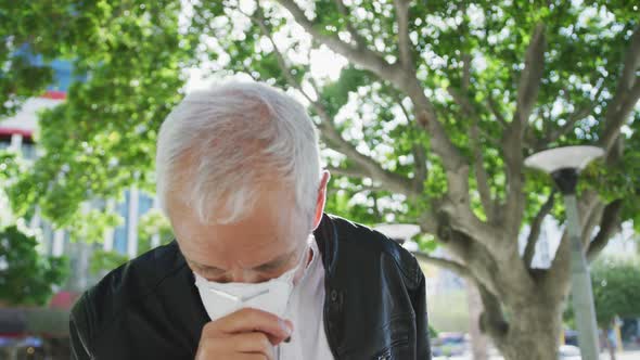 Caucasian man out and about in the street wearing on a face mask against coronavirus