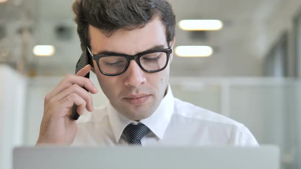 Businessman Talking on Phone at Work Frontal View