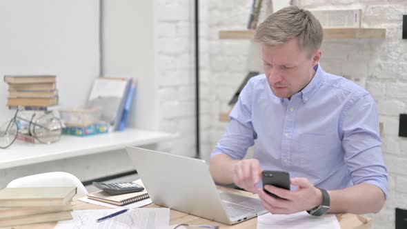 Businessman Working on Laptop and Phone