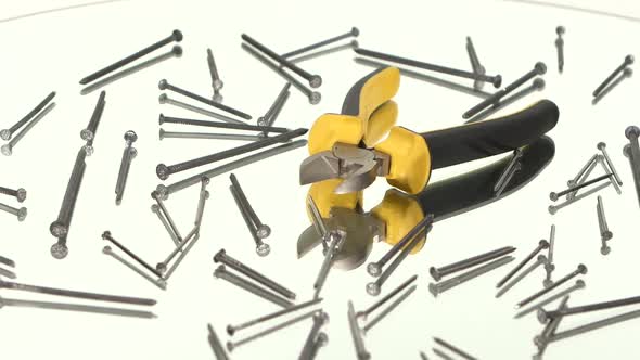 Mini Cutters with Yellow, Gray Handle on White Among Nails, Rotation, Reflection