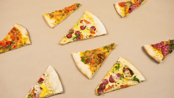Grop of triangular slices of different types of pizza pull together and spread to the cente