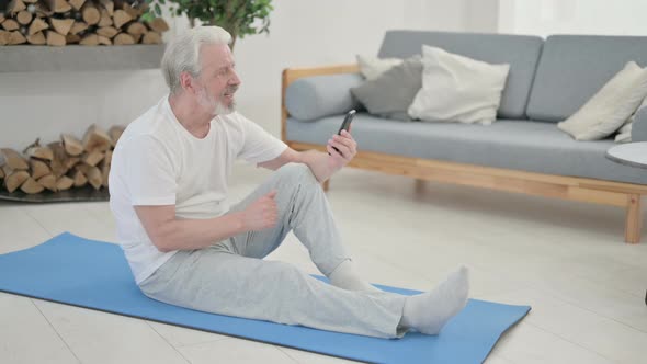 Old Man Talking on Video Call on Laptop While on Yoga Mat