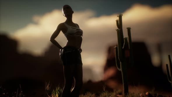 Woman in Torn Shirt Standing By Cactus in Desert at Sunset