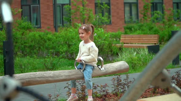 Girl Swing on Swing on Playground Outdoors