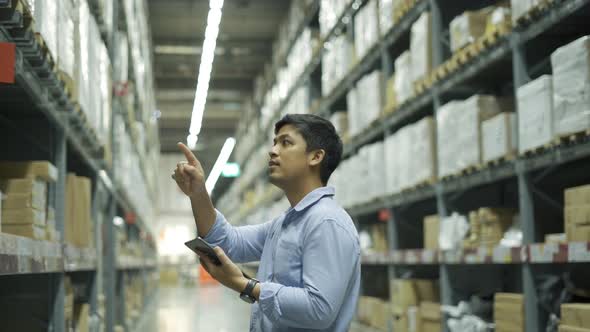 Man worker checking products with tablet in warehouse.