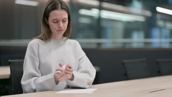 Frustrated Woman Writing on Paper in Office