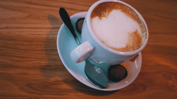 Cup of Cappuccino with White Foam on the Wooden Table in the Restaurant