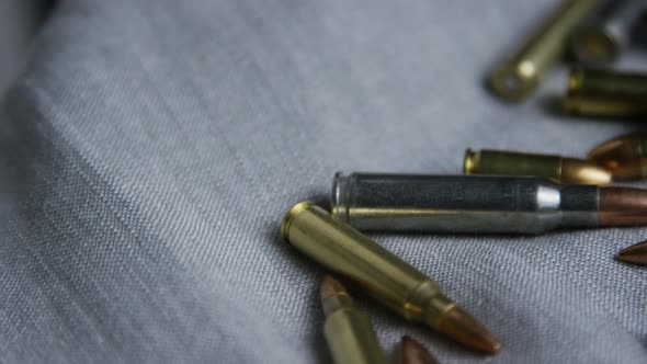 Cinematic rotating shot of bullets on a fabric surface - BULLETS 096