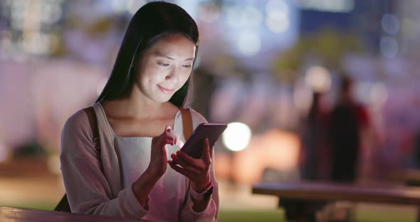 Woman use of mobile phone in coffee shop at night