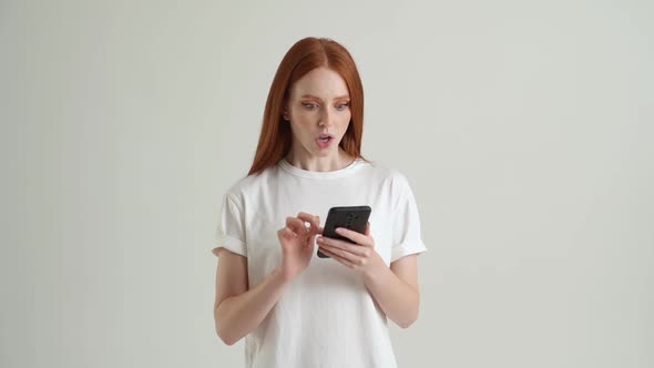 Portrait of Surprised Happy Young Woman Using Mobile Phone and Reading Message with Good News