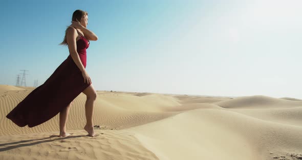 Model in Red Dress is Posing in the Great Sandy Desert of Dubai UAE Vacation