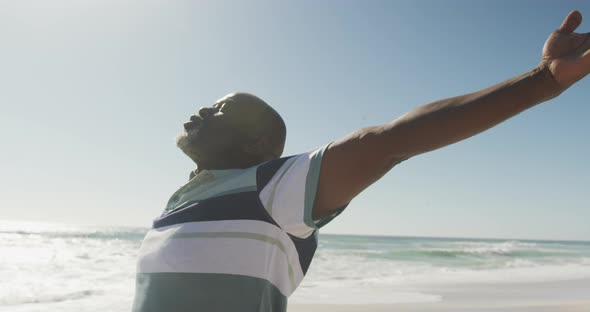 Senior african american man with arms wide on sunny beach