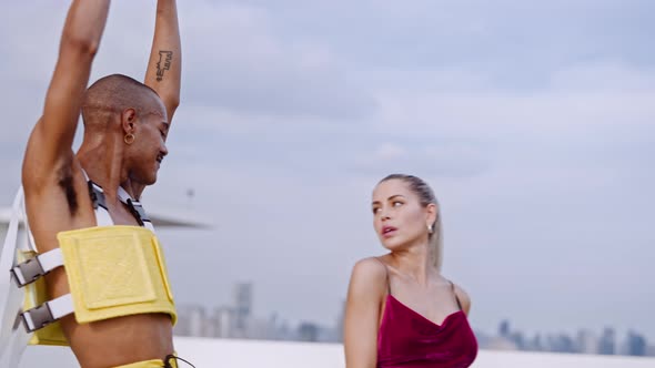 Man In Yellow Clubwear Spinning Around On City Rooftop