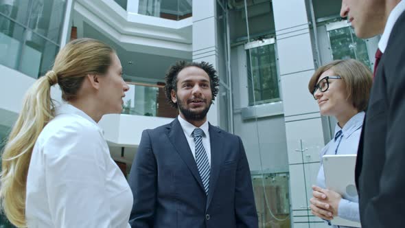 Team of Business Professionals Speaking in Office Center