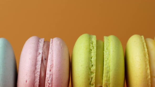 Multicolor Macarons, French macaroon, sweet tasty desserts. Isolated on a yellow background.