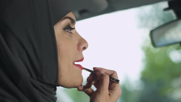 Seductive Muslim Lady Applying Red Lipstick in Automobile, Feminism, Coquette