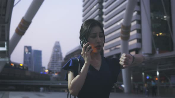 Woman Talking on Phone and Checking Watch