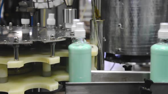 Conveyor of the production line with filling of transparent plastic bottles at the factory