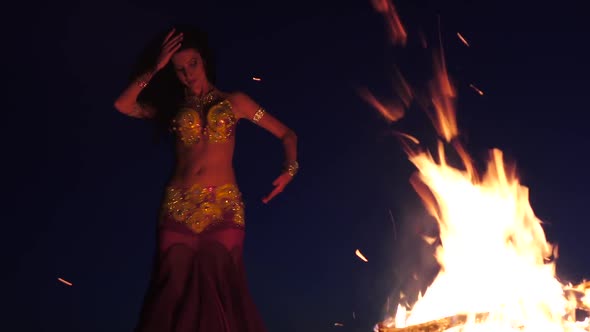 Late Night a Girl in the Sand Dancing Belly Dancing Near a Bright Campfire