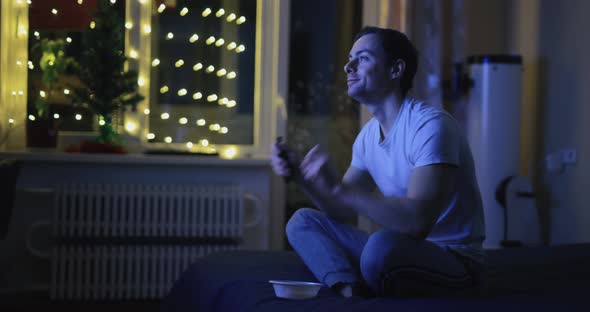 Joyful Man Watch TV and Dancing at Home