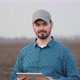Male Farmer is Working in Field with Digital Computer Looking at Camera Smiling - VideoHive Item for Sale