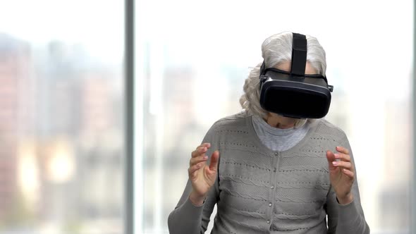 Mature Woman Wearing Virtual Reality Goggles.